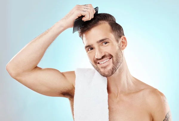 Hair care, man in portrait and beauty with comb and grooming with hygiene on blue background. Cosmetics, clean and fresh with hairstyle, wellness and routine with skin, glow and towel with skincare.