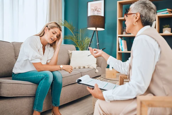 Woman on sofa, psychologist with advice and clipboard for mental health and consulting office. Stress, anxiety and depression, sad and depressed patient and healthcare therapist in consultation room