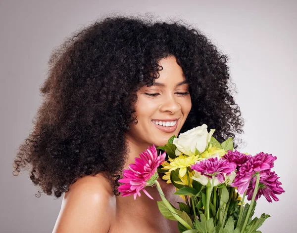Beauty, skincare or black woman with flowers in studio for body wellness, luxury spa or self care. Aesthetic facial, happy model or girl relax with plants for treatment, cosmetics product or nature.