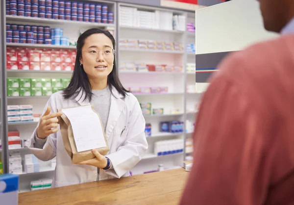 Medicine, pharmacist or doctor with patient in store with mockup prescription package for healthcare. Pharmacy woman giving man pills, advice and Pharma product for medical help, health and wellness.