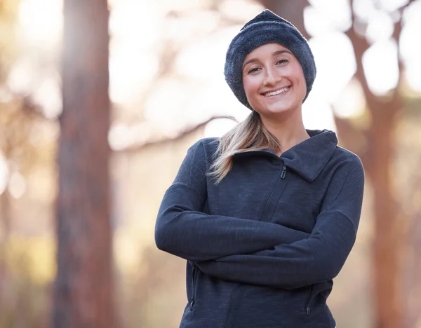 Portrait, arms crossed and smile of woman hiking outdoors for health and fitness. Winter sports, training and happy, confident and proud female hiker from Canada ready to start exercise in forest