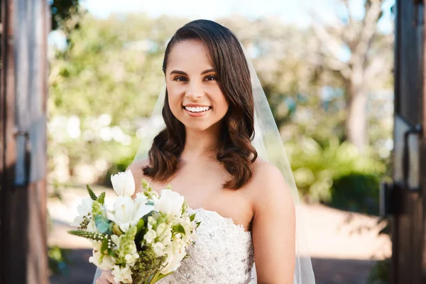 Ive always dreamed of holding a bouquet in a wedding dress. Cropped portrait of a beautiful young bride smiling while holding a bouquet of flowers on her wedding day