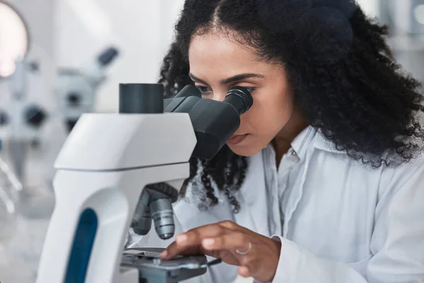 Science, microscope and sample with a doctor black woman at work in a lab for innovation or research. Medical, analysis and slide with a female scientist working in a laboratory on breakthrough.