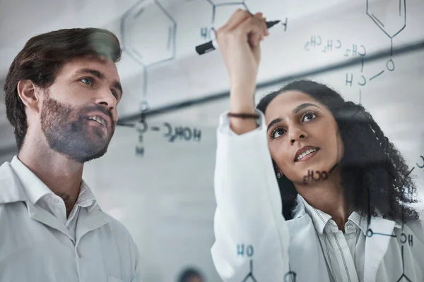 Teamwork, science and chemistry with people writing in laboratory for medicine, pharmacy or healthcare. Research, analytics and medical with scientists solving on glass board for idea, study or data.