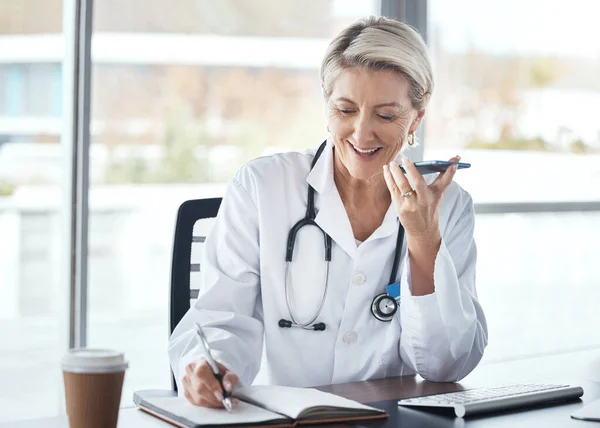 Woman, doctor and speaker phone, call and schedule appointment with health, writing notes and confirm consultation. Communication, tech and healthcare, calendar and senior medical employee at clinic.