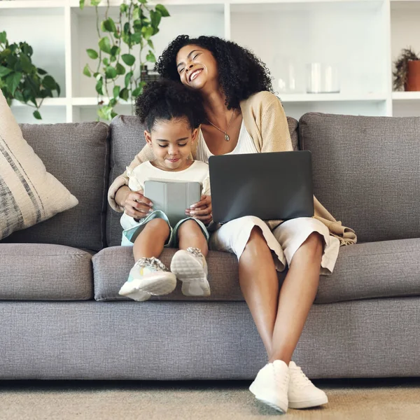 Mother, child and technology in family home living room for remote work, online education and wifi. Woman laugh and girl with laptop and table on couch for internet learning, game and funny movies.