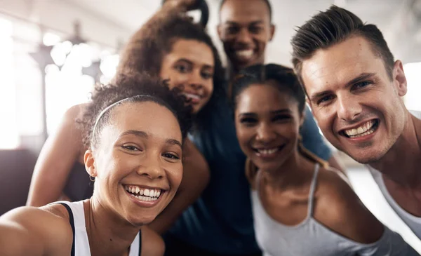 Fitness fans are m favourite kind of people. a group of young people taking a selfie together during their workout in a gym