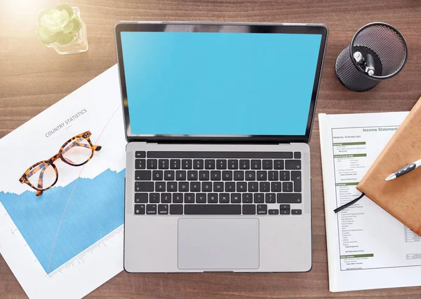 Mockup, green screen and documents with laptop on desk from above for finance planning, investment and review. Accounting, technology and overhead with device for growth, savings and tax report.