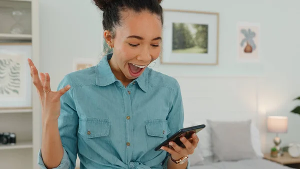Excited woman, phone and notification at home while happy with wow reaction for winning competition, goal or challenge online. Female in bedroom reading message or chat for results or score for game.