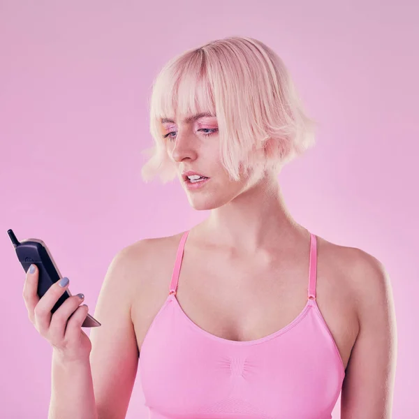 Retro phone, fashion and woman with problem on pink background with network issue, glitch or spam. Creative aesthetic, beauty and confused girl with vintage cellphone, makeup and cosmetics in studio.