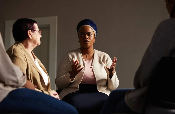 Support, black woman and senior group therapy with understanding, feelings and talking in session. Mental health, grief or depression, people in retirement with therapist sitting together for healing.