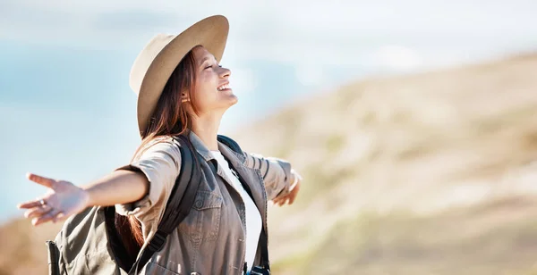 Woman, tourist and smile for travel freedom, hiking adventure or backpacking journey on mountain in nature. Female hiker smiling with open arms enjoying fresh air, trekking or scenery on mockup.