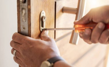 Locksmith hands, maintenance and handyman with tools, home renovation and fixing, change door locks and closeup. Construction, building industry and trade with manual labour, vocation and employee. clipart