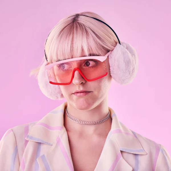 Woman, fashion and unique on a pink background in studio with funny glasses for cyberpunk style. Face of edgy, trendy or retro aesthetic person thinking vaporwave, creativity and art color clothes.