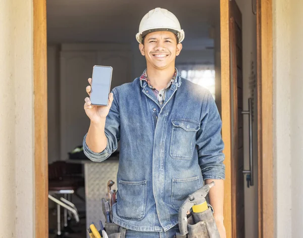 Construction worker, man in portrait and phone, screen with mockup and contact, digital marketing and handyman. Home renovation, maintenance and industry trade promo with product placement advert.
