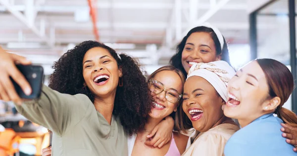Phone, women or employees in a work selfie for fun social media content or team building in an office. Diversity, smile or team of happy coworkers or friends taking pictures or bonding on lunch break.