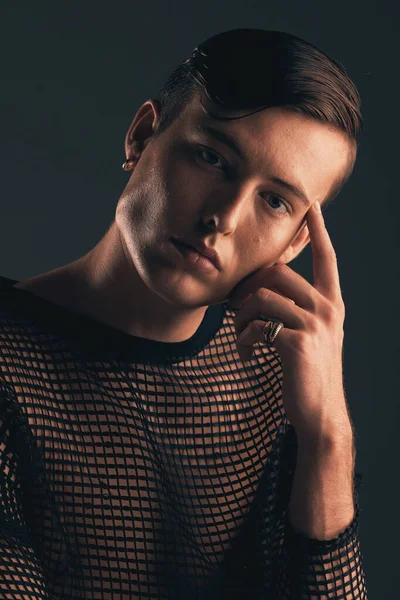 Gender neutral person, fashion and portrait on dark background, trendy and edgy. Creative, gen z and thinking with beauty, sexy with cosmetics and serious, non binary and designer clothes in studio.