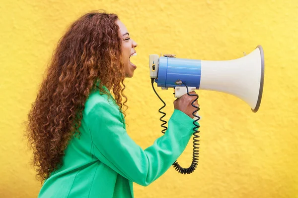 Megaphone, woman and screaming on yellow background of speech, broadcast and protest noise. Female, announcement and shouting voice for justice, news and attention of opinion, gen z speaker and power.