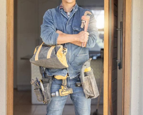 Handyman, tool bag and arms crossed at work with goals, property development and real estate maintenance. Construction worker, tools and renovation industry with service, vision and home improvement.