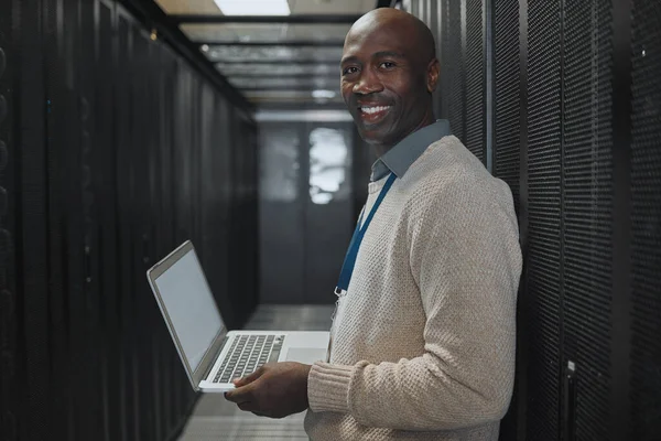 Server room, laptop and man portrait or technician for data center, system and cybersecurity code. Happy African programmer or programming person in information technology, ethernet or power solution.