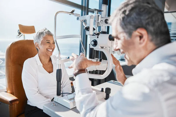 Eye doctor, machine or happy woman consulting for help with eyesight at optometrist in an optical assessment. Optician talking or asking senior customer info testing for vision, iris or retina health.