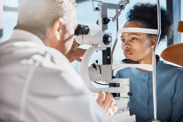 Help, eye exam or black woman consulting doctor for eyesight at optometrist or ophthalmologist. African customer testing vision with mature optician checking iris, glaucoma or retina visual health.