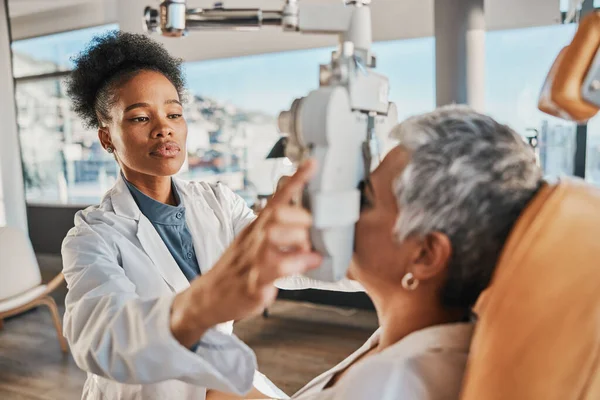 Eye exam, vision and black woman with patient in optometry clinic for eyesight and optical assessment. Healthcare, optometrist consultation and doctor medical equipment, phoropter and lens for eyes.