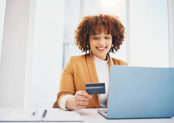 Black woman, laptop and office with credit card for e-commerce or shopping on web with smile for cybersecurity. Corporate executive, computer and ecommerce for retail, discount and fintech at desk.