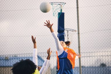 Netball, kale atışı ve açık hava spor sahasında bir kız atlet grubunun savunması. Atış, spor oyunu ve maç müsabakasında spor ve idman yapan siyah bir kişinin meydan okuması.