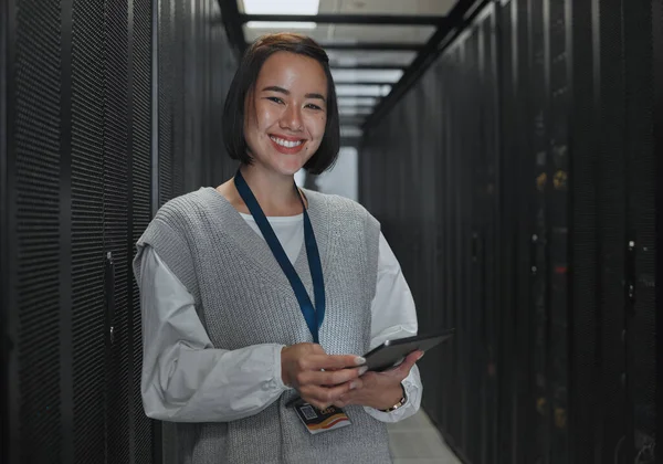 Asian woman, portrait smile and technician with tablet in server room for networking, maintenance or system inspection. Happy female engineer smiling with touchscreen in data management or monitoring.