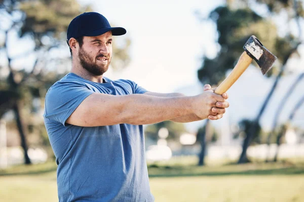 Sports, archery and man throw axe on range for training, exercise and target practice competition. Extreme sport, fitness and male archer aim with tomahawk weapon for action, games and adventure.
