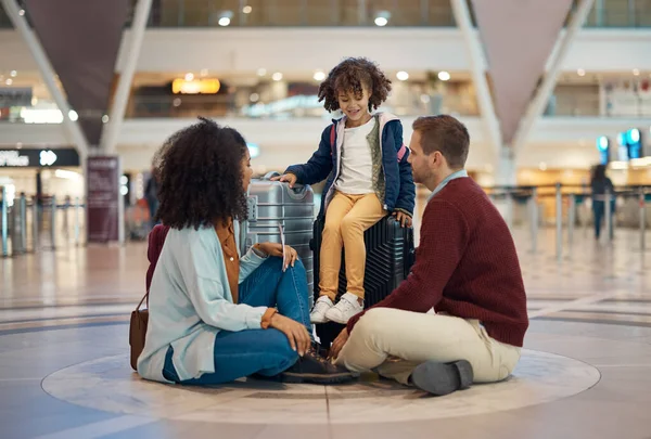 Family at airport, travel and waiting with luggage, mother and father with child, relax with flight delay and adventure. Terminal, journey and holiday with black woman, man and kid with suitcase.