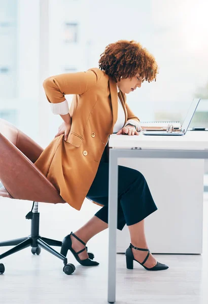 Black woman in business with back pain, burnout and stress, stiff muscle from spine injury and overworked. Female worker at desk, corporate and medical emergency with health problem and strain.