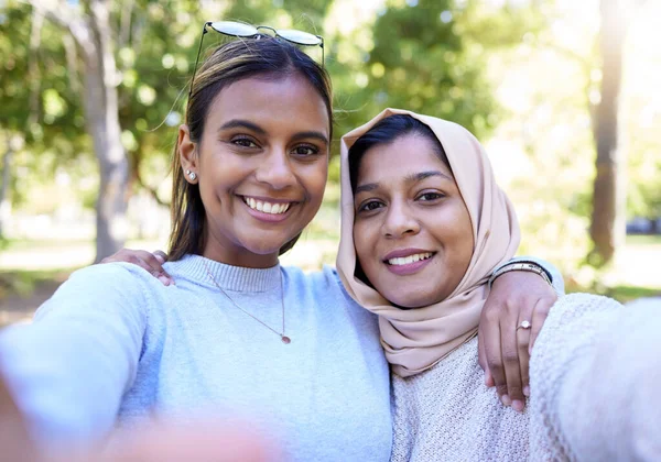 Women, muslim and friends selfie in park, nature and happiness for bonding on social network app. Happy gen z woman, profile picture and hug portrait in woods, outdoor and support together on travel.