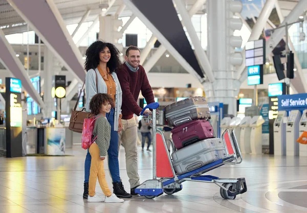 Travel, airport and happy family with suitcase trolley for holiday, vacation or immigration journey. Luggage of black woman or diversity parents with child or kid walking in lobby excited for flight.