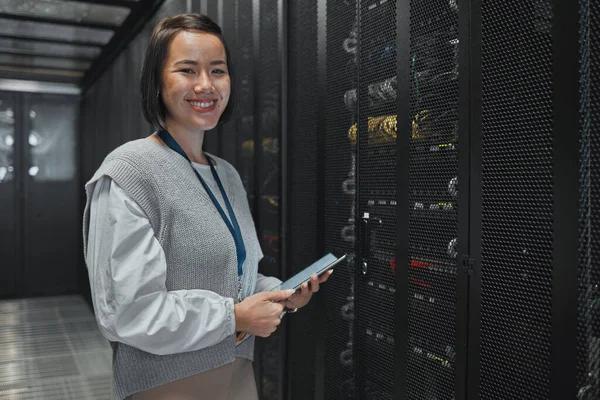 Asian woman, portrait and tablet of technician by server for networking, maintenance or systems at office. Happy female engineer smile for cable service, power or data administration or management.