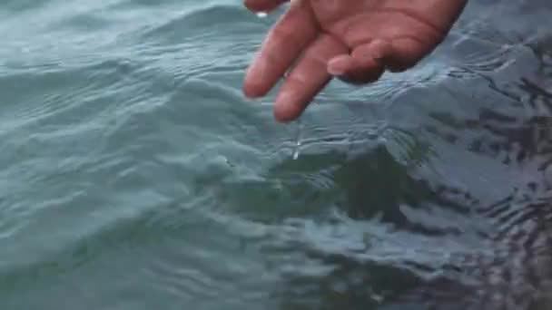 해변의 바다나 바다에 여인의 손으로 여성의 손가락으로 H2O 흐름을 허용하는 — 비디오
