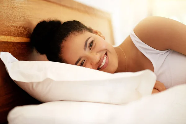 Wake up in a good mood, have a great day. Portrait of a happy young woman waking up in bed feeling well rested