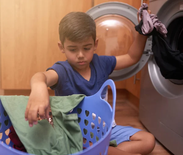人生の重要なスキルを学ぶ 小さな男の子が洗濯機に服を入れて — ストック写真