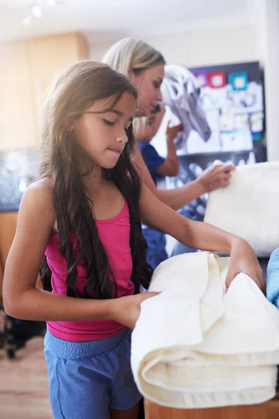 責任ある子供を育てる 家で小さな女の子と母親がタオルを折り — ストック写真