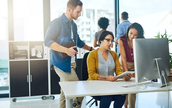 stock image Working through their strategic plans. a group of colleagues working together on a digital tablet in a modern office