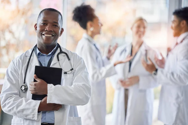 Black man, doctor portrait and tablet with medical team in hospital ready for healthcare work. Wellness, health and medic employee in a clinic feeling happiness and success with blurred background.