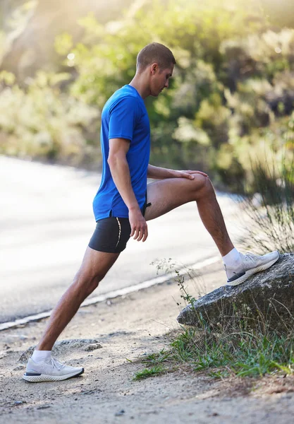 stock image Stretching legs, fitness and man in nature getting ready for running, exercise or workout. Sports health, training or male athlete warm up or preparing to start cardio, exercising or jog for wellness.