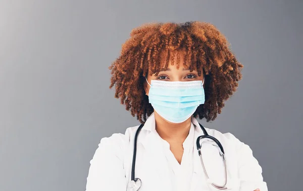 Portrait, mockup and healthcare with black woman, mask and safety regulations against grey studio background. Face cover, Jamaican female doctor and medical professional with stethoscope and trust.