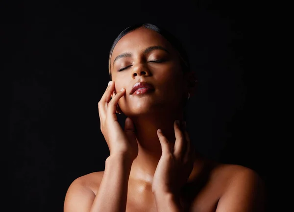 stock image Beauty, skincare and face of a woman in studio for makeup, cosmetics and dermatology hands on skin. Young aesthetic model person on a black background for luxury self care, facial glow and results.