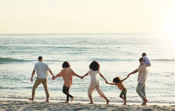 Walking, big family and holding hands at beach at sunset, having fun and bonding on vacation outdoors. Care, mockup and kids, grandmother and grandfather with parents at ocean enjoying holiday time