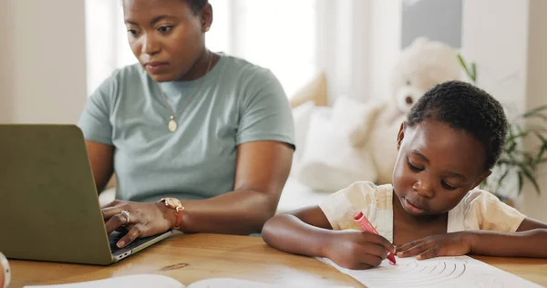 Mother typing on laptop with kid in living room and kiss child care support in working from home online. African girl drawing at table, black mom writing business email and elearning technology.