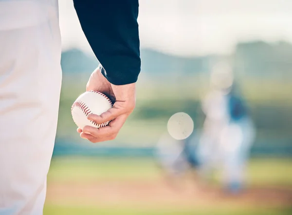 Baseball player, ball and athlete or pitcher hand in a competitive match or game on the sports field for training. Closeup, sportsman and person playing a sport or softball as exercise and fitness.