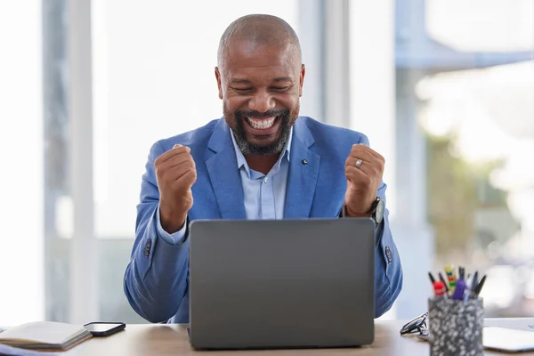 Happy black man, laptop and celebration for winning, sale or good news on discount at the office desk. Excited African American male celebrating on computer for promotion, bonus or achievement.