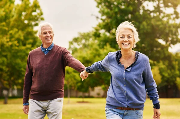 老夫妇手牵着手 在户外公园里笑着 幸福与自然的自由 爱和退休 有旅行的男人和女人 对婚姻的信任和承诺 — 图库照片